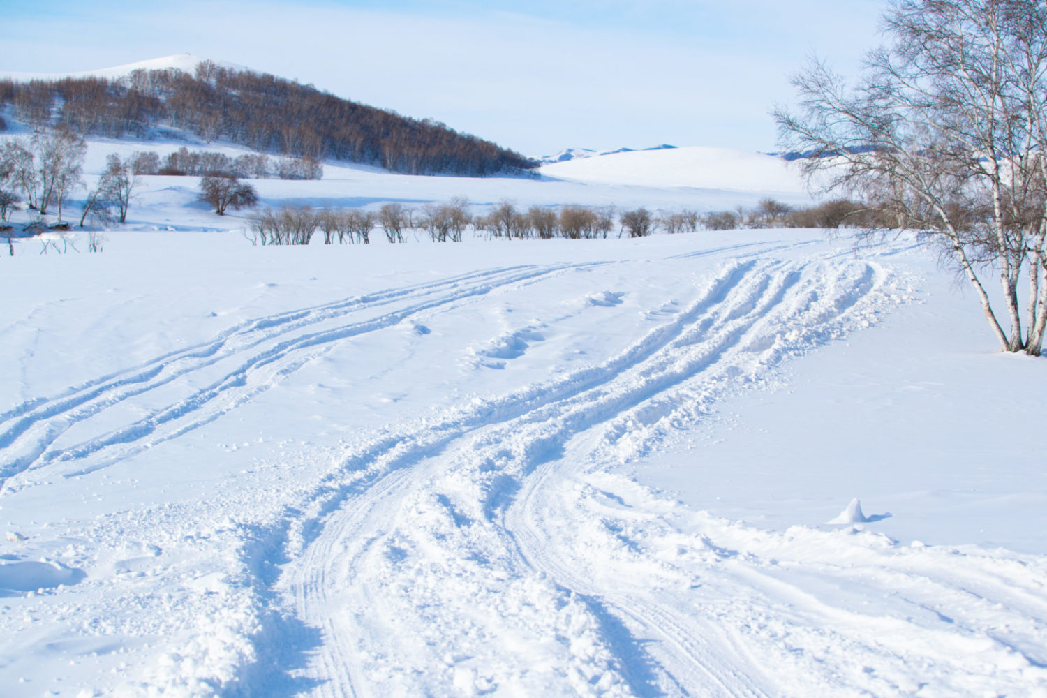 A countryside landscape is seen covered in a blanket of white snow.